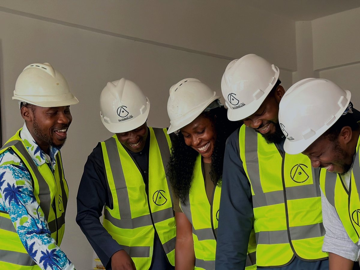 Teimetra consultants on a site visit at a client operations facility, wearing hard hats and safety vests